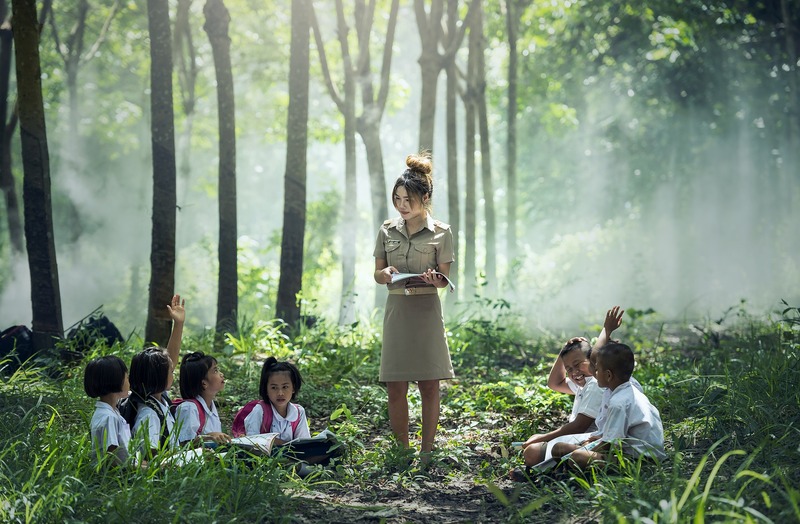 An asian teacher is educating her students in the forest (picture taken with Nikon D810 and Nikon AF-S 70-200mm F2.8 G IF-ED VR II )