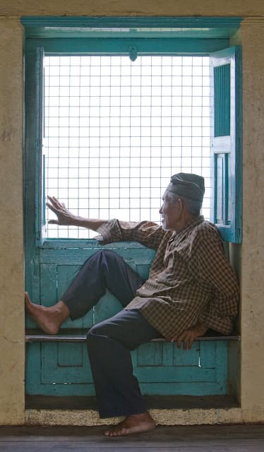 Nepalese gentleman is looking out of window (picture taken with Canon EOS 1D Mark III and Canon EF 70-200mm F2.8 L IS USM )
