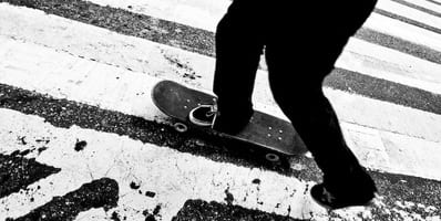Person with skateboard on pedestrian crossing