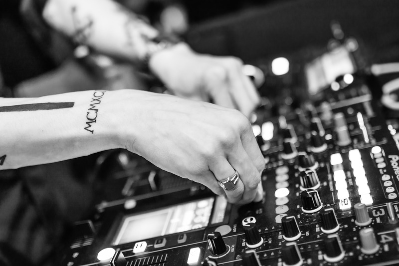 DJ with a tattoo on his forearm at his Pioneer mixer table (picture taken with Nikon D7100 and Nikon AF-S 35mm f/1,4 G)