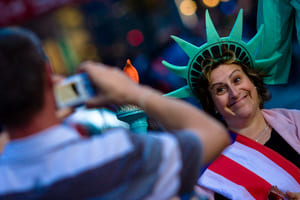 Tourist taking picture of his wife dressed as Statue of Liberty