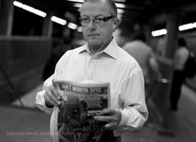 Man reading his news paper in subway