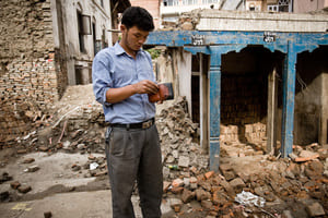 Guy inspecting his wallet among ruins